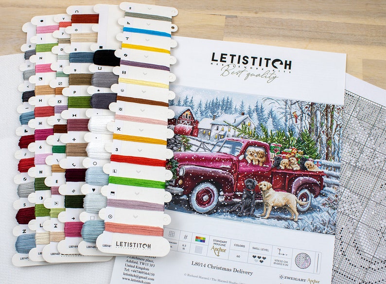 May include: A cross stitch pattern featuring a red pickup truck with a Christmas tree in the back and a group of dogs. The pattern is titled "L8014 Christmas Delivery" and is by Zweigart Anchor.