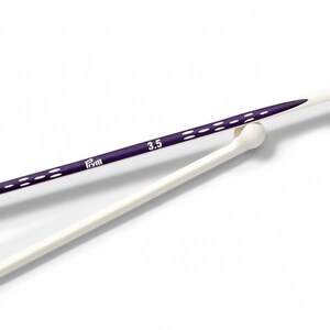 May include: A pair of purple knitting needles with white markings and the text "Prym 3.5" on the needle. The needles are resting on a white knitting needle.