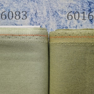 May include: Two fabric swatches, one labelled "6083" and the other "6016". Both swatches are a light green colour with a subtle texture. The fabric has a thin orange thread running along the edge.