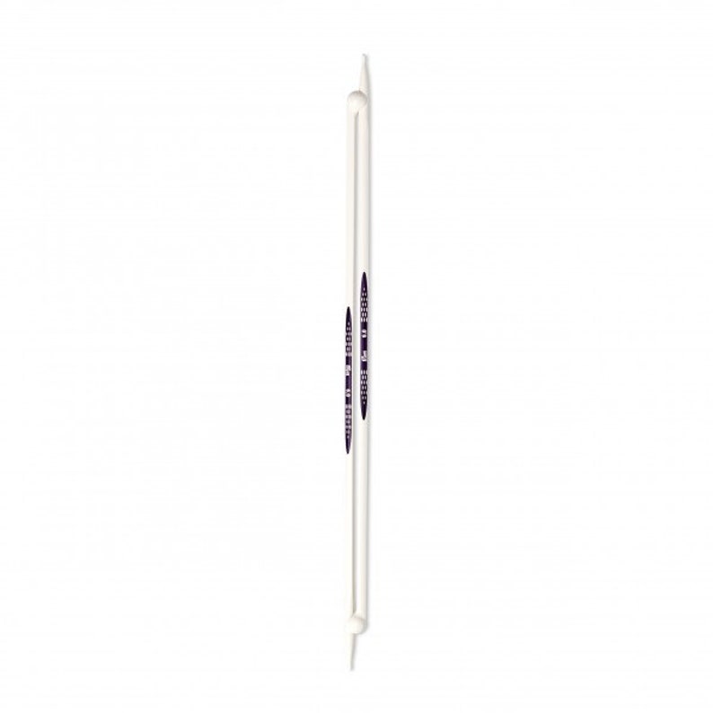 May include: A pair of white knitting needles with black and white markings. The needles are approximately 10 inches long.