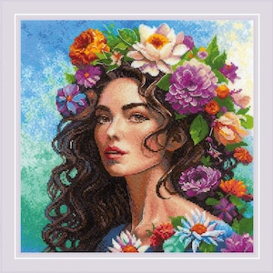 May include: A woman with long brown hair wears a crown of colorful flowers. The flowers are a mix of white, purple, pink, orange, and yellow. The woman's face is visible and she is looking to the right.
