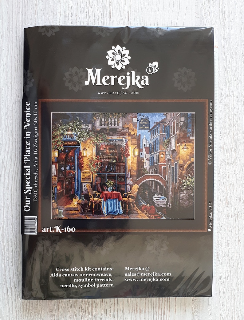 Puede incluir: Kit de punto de cruz con una representaci&oacute;n colorida de una escena de canal en Venecia, Italia. El kit incluye hilos DMC, tela Aida, una aguja y un patr&oacute;n de s&iacute;mbolos. El kit se titula "Our Special Place in Venice" y tiene el n&uacute;mero de art&iacute;culo K-160.