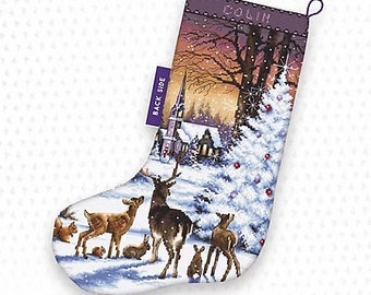 May include: A white Christmas stocking with a purple trim and the word "Colin" printed on the top. The stocking features a winter scene with a church, a snowy forest, and a deer family. The back of the stocking has the words "Back Side" printed on it.
