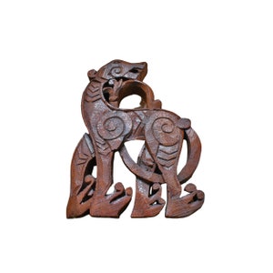 May include: A wooden carving of a stylised animal, possibly a wolf or a dog, with intricate details and a dark brown colour.