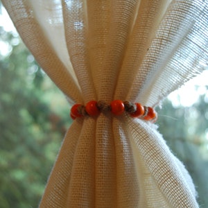 Rustic beaded jute curtain tie back with orange beads and natural jute rope. Custom made to order in various sizes. Fall holiday decor.