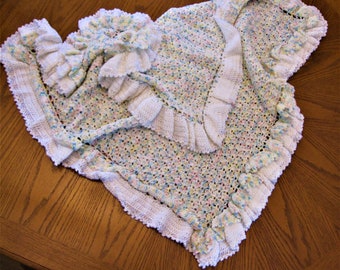 Crochet, double ruffled baby blanket/afghan in white, pink, yellow and blue.