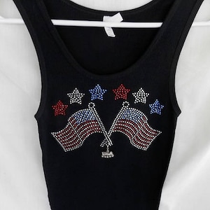 May include: Black tank top with a rhinestone design of two American flags and stars.