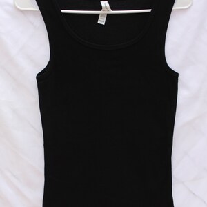 May include: A black tank top with a scoop neck. The tank top is made of a soft, stretchy fabric.