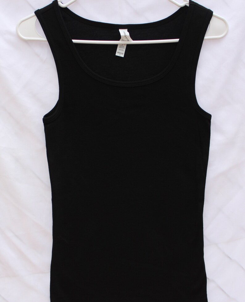 May include: A black tank top with a scoop neck. The tank top is made of a soft, stretchy fabric.