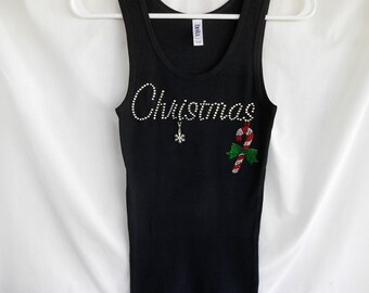May include: Black tank top with a rhinestone design that says "Christmas" with a snowflake and candy cane.