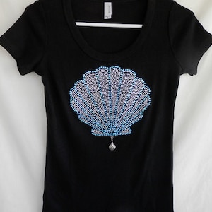 May include: Black t-shirt with a blue and silver rhinestone seashell design.
