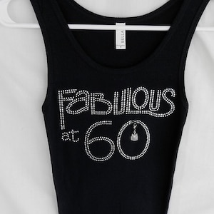 May include: Black tank top with rhinestones spelling "Fabulous at 60" with a small rhinestone birthday cake charm.