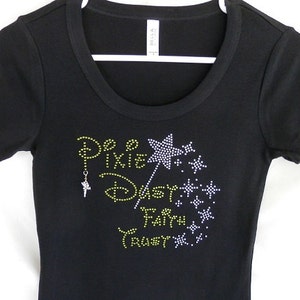 May include: Black t-shirt with a sparkly yellow and white design that says "Be Pixie Dust Fairy Trust" with a silver fairy charm.