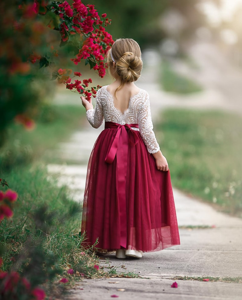 Burgundy long sleeve flower girl dress made of lace and tulle, designed for toddlers, girls, and junior bridesmaids attending fall or winter weddings.