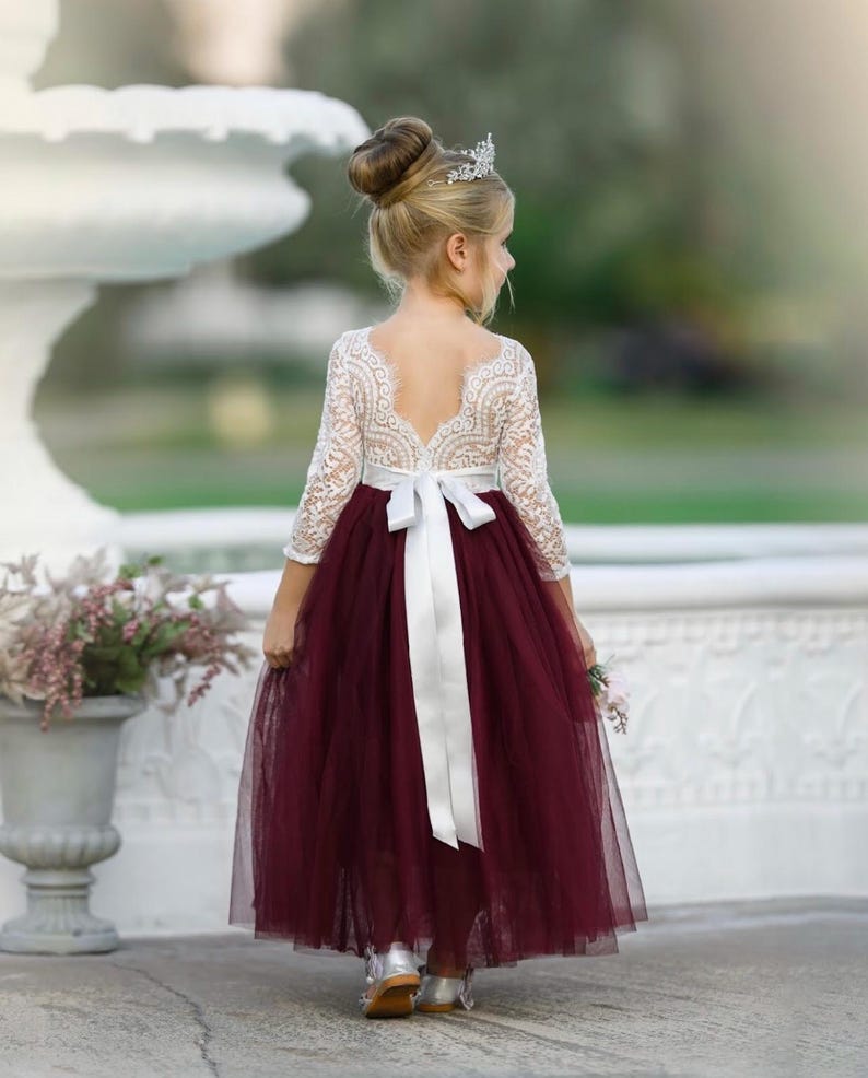 Long sleeve lace and tulle flower girl dress available in sage green, dusty blue, blush, ivory, burgundy, and more, perfect for all wedding styles.