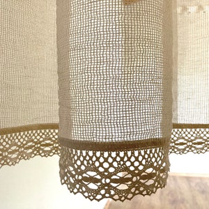 May include: A pair of off-white sheer curtains with a delicate lace trim. The curtains are made of a lightweight, airy fabric and have a subtle texture.