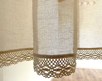 May include: A pair of off-white sheer curtains with a delicate lace trim. The curtains are made of a lightweight, airy fabric and have a subtle texture.