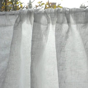 May include: White sheer curtains with a gathered top, hanging in a window. The curtains are made of a lightweight fabric with a subtle texture.