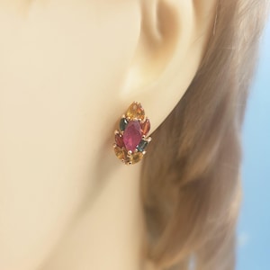 May include: A cluster earring featuring a central marquise-cut pink gemstone surrounded by smaller marquise-cut stones in shades of yellow, orange, red, and dark green, all set in a rose-gold tone metal frame that secures to the earlobe.