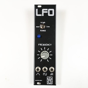 Peut inclure: Module LFO noir avec une étiquette blanche qui indique "LFO". Le module possède un bouton intitulé "FREQUENCY" et un interrupteur intitulé "RANGE" avec les options "high", "med" et "low". Il y a trois prises étiquetées "^", "||" et "M".