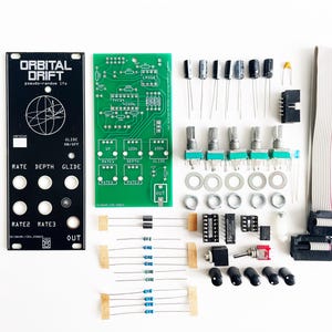 May include: A selection of electronic components for a DIY project, including circuit boards, potentiometers, and various small parts. The black panel reads "ORBITAL DRIFT" and "pseudo-random lfo". The components are arranged on a white surface.