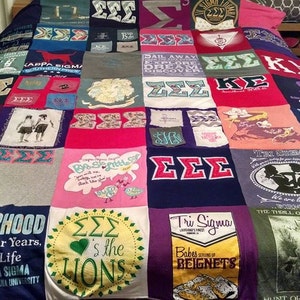 May include: A patchwork quilt made from t-shirts with various designs and text, including "Sisterhood", "Tri Sigma", "It's Not Four Years, But For Life", "Sigma Sigma Sigma", "Southeastern Louisiana University", "The Thrill of the Chase", "Babes Serving Beignets", "Hunt or Be Hunted", and "ZZS's the Lions".