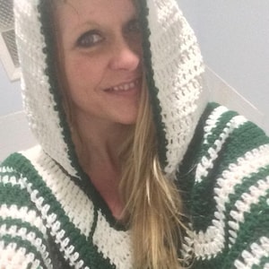 May include: A green and white crocheted hooded sweater with a striped pattern.