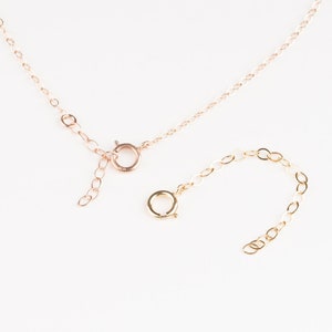 Puede incluir: Un collar de cadena de oro con cierre de mosquetón y una cadena extensora. El collar está hecho de una cadena delicada y es perfecto para superponer.