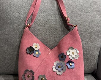 Bolso pequeño Naomi de Portland Leather Goods PLG en gamuza rosa con apliques de flores de cuero personalizados.