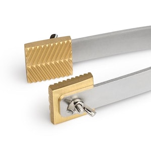 May include: A pair of silver-toned tweezers with gold-toned tips. The tips have a textured surface.