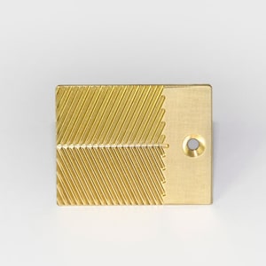 May include: A gold-colored metal tool with a textured surface and a small hole. The tool is designed for crafting and has a unique pattern.