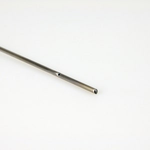 Op de afbeelding: Een zilveren metalen buis met een klein gaatje aan de zijkant.