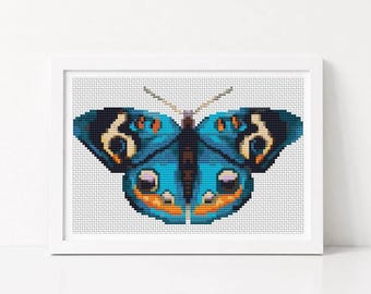 May include: A cross-stitch embroidery of a butterfly with vibrant blue wings, featuring dark brown, orange, and cream-colored patterns. The butterfly is centered within a white rectangular frame, showcasing a detailed grid-like stitch texture.