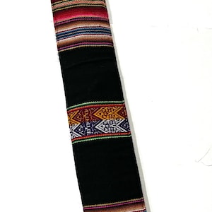 May include: Black fabric strap with colorful woven patterns in red, orange, yellow, green, blue, purple, and white. The strap has a geometric design.