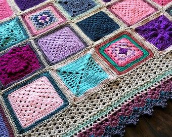 May include: A crocheted blanket with a variety of colorful squares in shades of pink, purple, blue, and green. The blanket has a crocheted border with a scalloped edge.