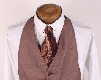 May include: A brown patterned vest with five buttons. The vest is worn over a white dress shirt with a brown and orange patterned tie.