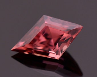 May include: A pink, faceted, square-shaped gemstone with a slight tilt.