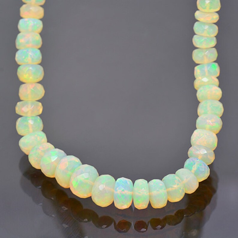 May include: A strand of white opal beads with a faceted finish. The beads are strung on a clear thread and are approximately 4mm in diameter.