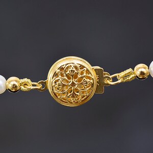 May include: A gold necklace with a decorative clasp and white pearls and opals.