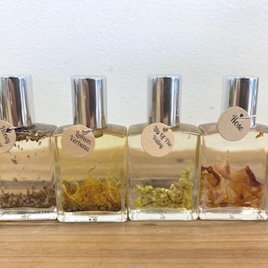 May include: Four small glass bottles with silver caps and brown labels. The labels have different floral scents: Honey Flower, Lemon Verbena, Lily of the Valley, and Rose.