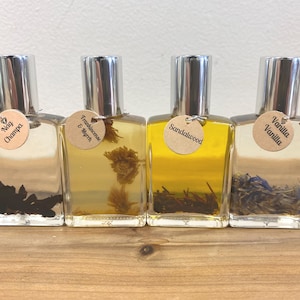 May include: Four small glass bottles with silver caps and brown paper labels. The labels have the names of different scents: Nag Champa, Frankincense & Myrrh, Sandalwood, and Vanilla Vanilla.