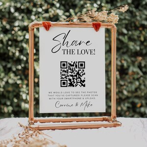 May include: A white sign with a copper pipe frame, featuring a QR code and the text "Share the Love!"  We would love to see the photos that you've captured! Please scan with your smartphone & upload. Corrine & Mike.