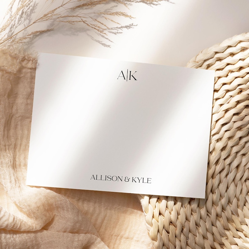 May include: A white card with the initials "A|K" and the text "ALLISON & KYLE" printed in black.