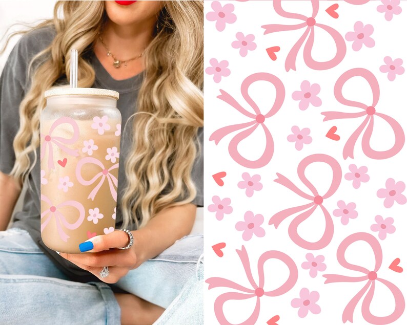 May include: A glass tumbler with a bamboo lid and straw, decorated with pink bows, flowers, and hearts. The tumbler is filled with a light brown beverage. A matching pattern of bows, flowers, and hearts is on a white background.