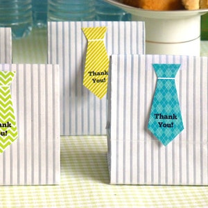 May include: Four striped paper bags with tie-shaped thank you tags. The tags are in yellow, green, and blue with a chevron, diamond, and solid pattern. The text on the tags reads "Thank You!"