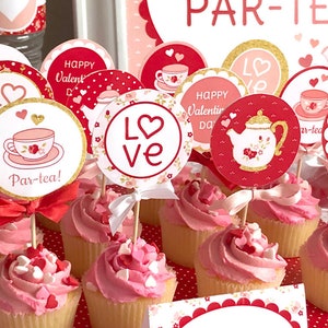 May include: Valentine's Day party cupcake toppers with red, white, and gold designs. The toppers feature hearts, teacups, teapots, and the words "Love", "Par-tea!" and "Happy Valentine's Day!"