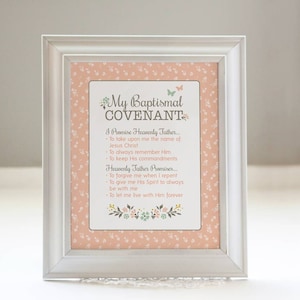 May include: A framed print with a pink background and white floral pattern. The text reads "My Baptismal Covenant" and includes promises made to Heavenly Father and promises made by Heavenly Father.