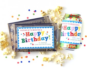 May include: A colorful birthday gift set with a bag of popcorn, a can of soda, and a personalized gift tag that says "Popping by to wish you a Happy Birthday!"