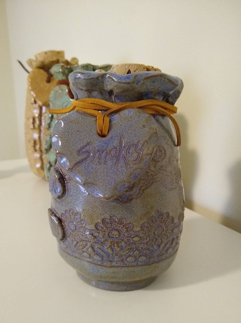 your choice of color and size. Ceramic Pet Urn is embossed with lace and personalized with a heart hung on a leather cord with pet/'s name