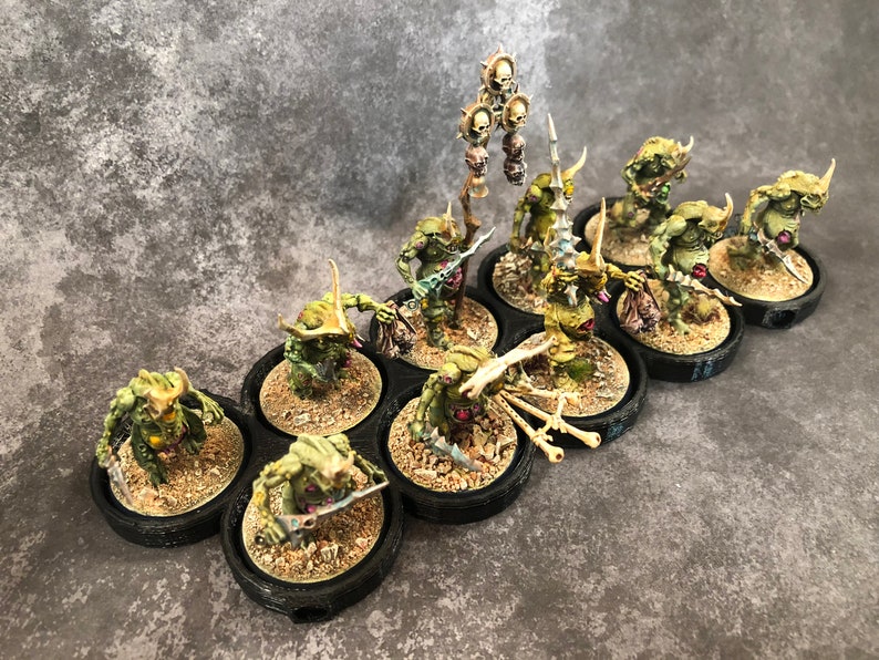 Peut inclure: Un groupe de dix figurines miniatures peintes en vert et brun avec des &eacute;p&eacute;es et des armes en os sur des socles noirs. Les figurines sont dispos&eacute;es en ligne et sont pr&ecirc;tes pour le combat.